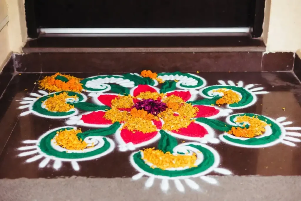 Aesthetic rangoli at doorstep with peacock motif and flower petals