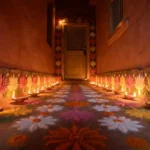 Beautiful floral border rangoli design along a home entrance corridor with marigold colors