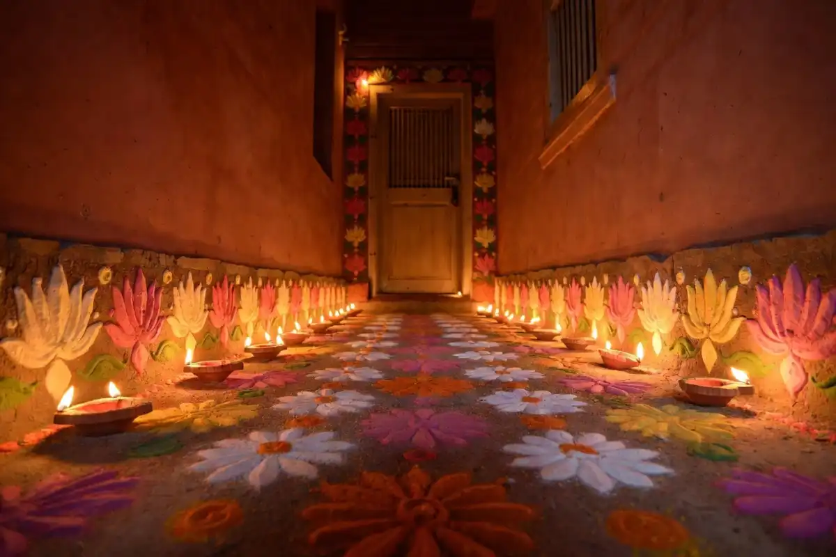 Beautiful floral border rangoli design along a home entrance corridor with marigold colors