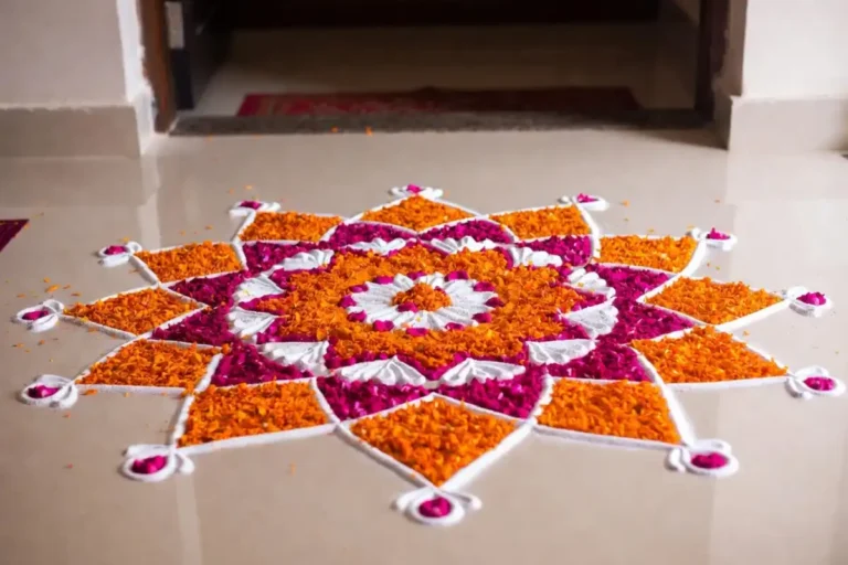 Colorful floral design rangoli at home entrance with vibrant petals