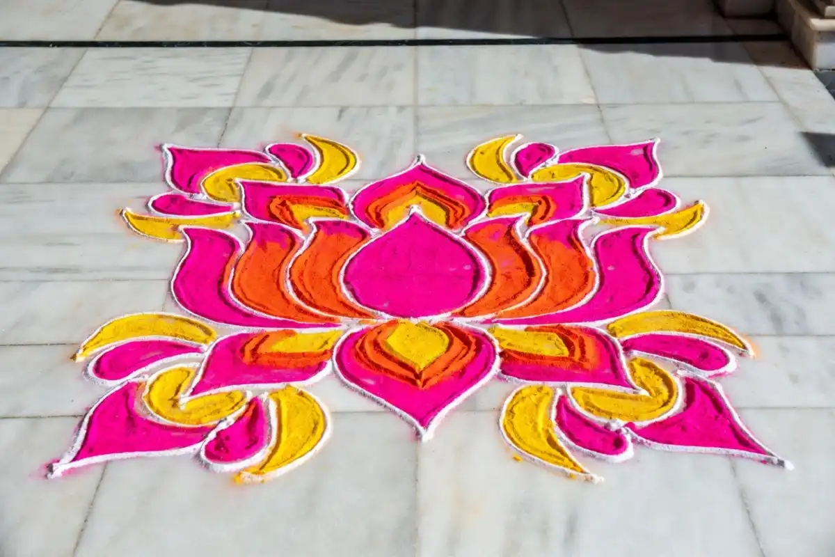 Colorful rangoli border design with floral patterns on floor