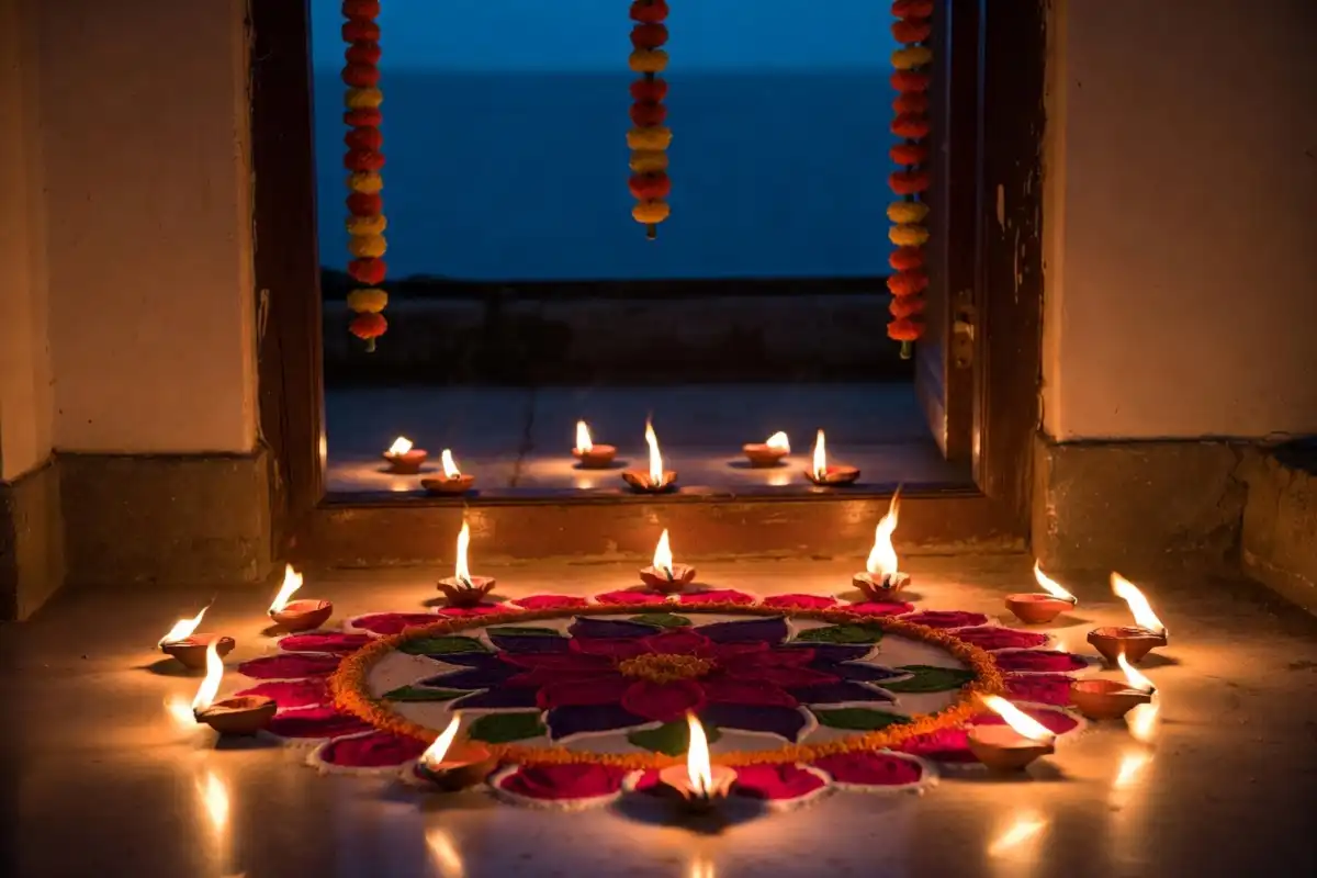 Traditional Dhanteras rangoli design at home entrance surrounded by glowing diyas at dusk