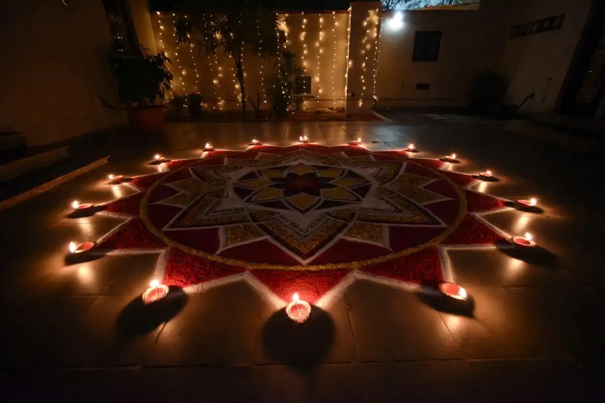 Diwali rangoli design with diya border glowing at night during the festival