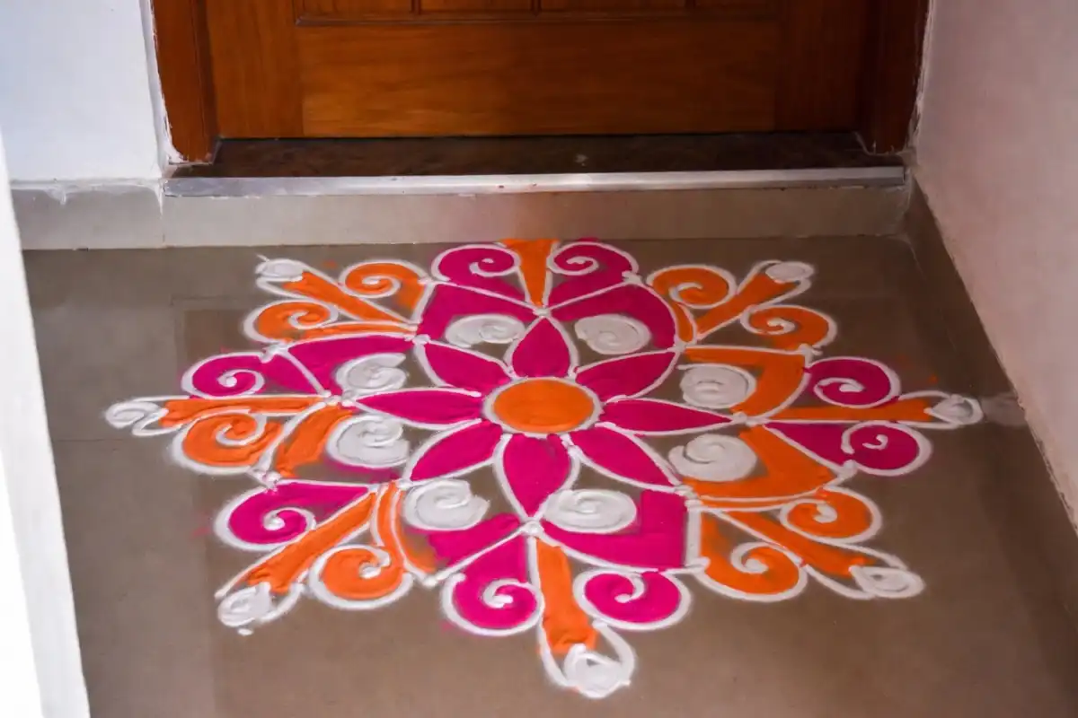 Easy rangoli designs for small space near a doorstep in pink and orange
