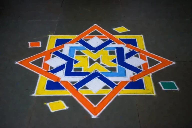 Symmetrical geometric rangoli design with triangles, hexagons, and diamond shapes in vibrant colors