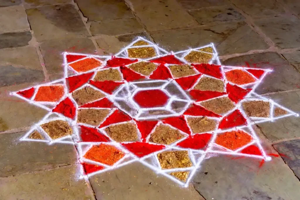 Geometric rangoli design featuring hexagons, concentric circles, and triangular rays in red and gold