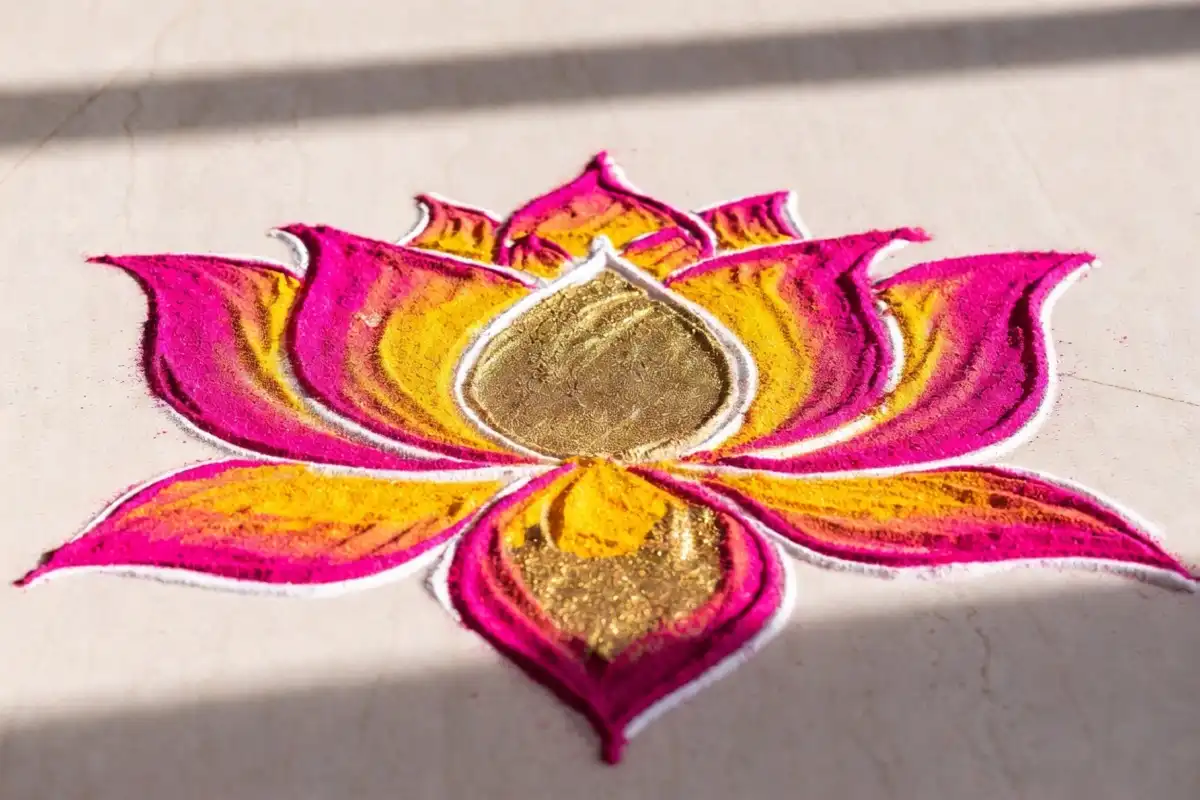 Intricate pink and gold lotus Dhanteras rangoli design with detailed petal work