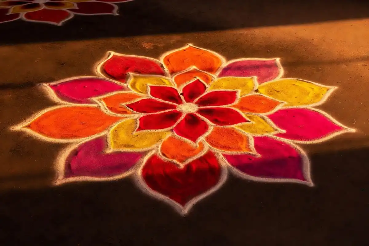 Colorful ornamental floral rangoli design in a circular pattern with layered petals