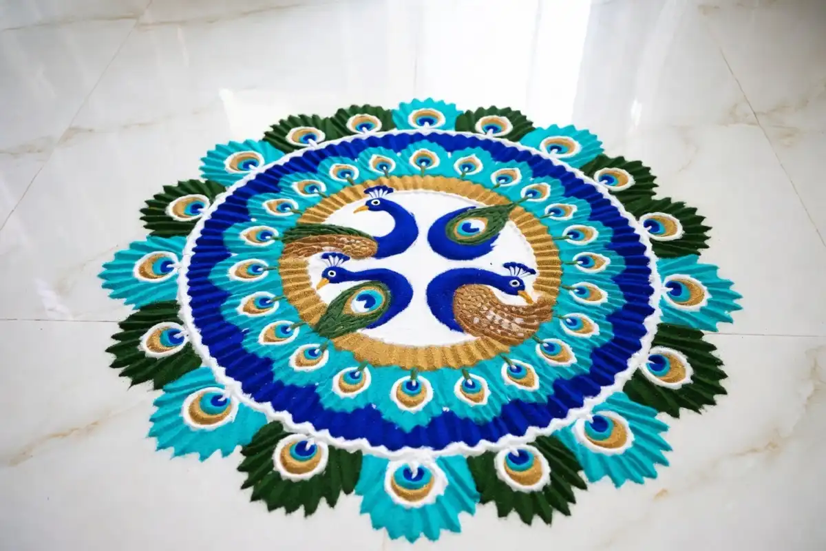 Colorful peacock circle rangoli design made with vibrant powder colors on floor