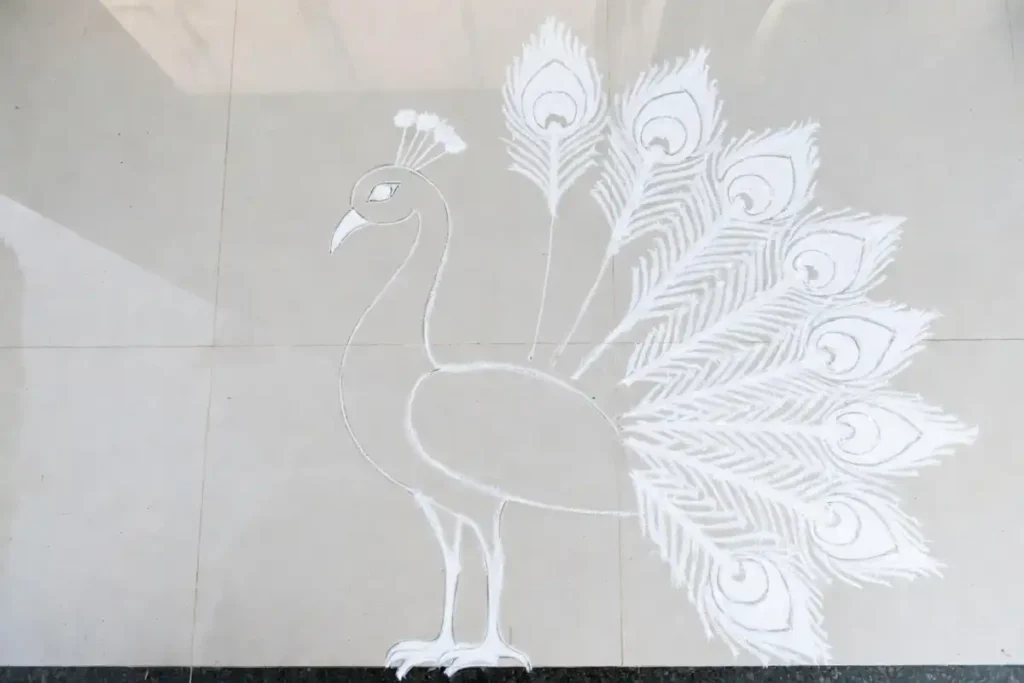 Easy peacock rangoli design step-by-step chalk outline showing body, tail fan, and feather sections on a floor