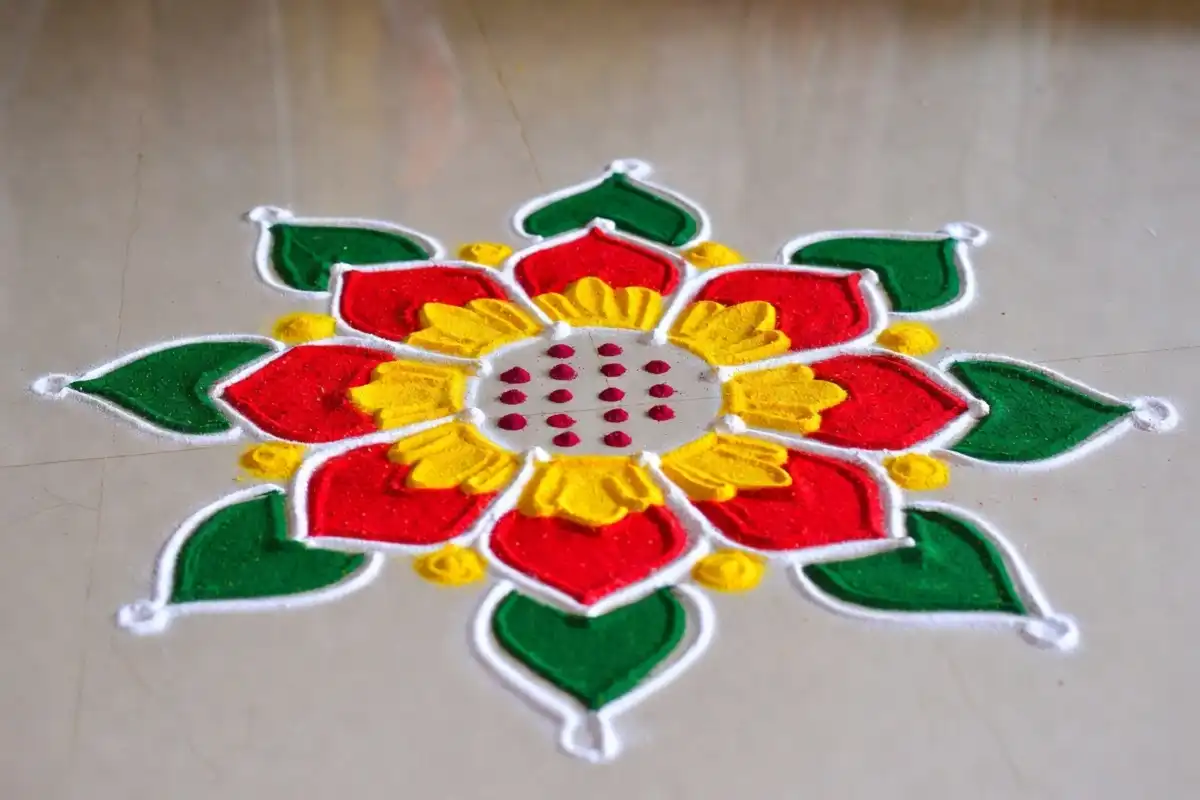 Colorful rangoli easy design with floral pattern drawn on floor using colored powder