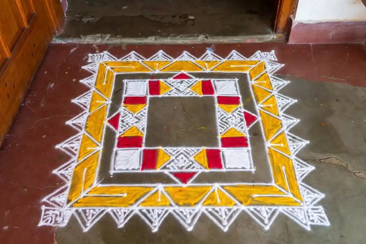 Simple geometric rangoli border design using white and yellow powder