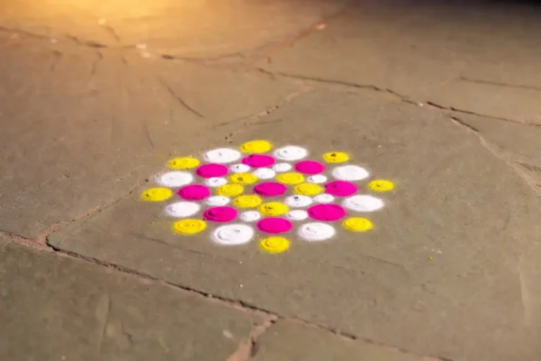 Small rangoli designs with dots arranged in a colorful floral pattern on a stone floor