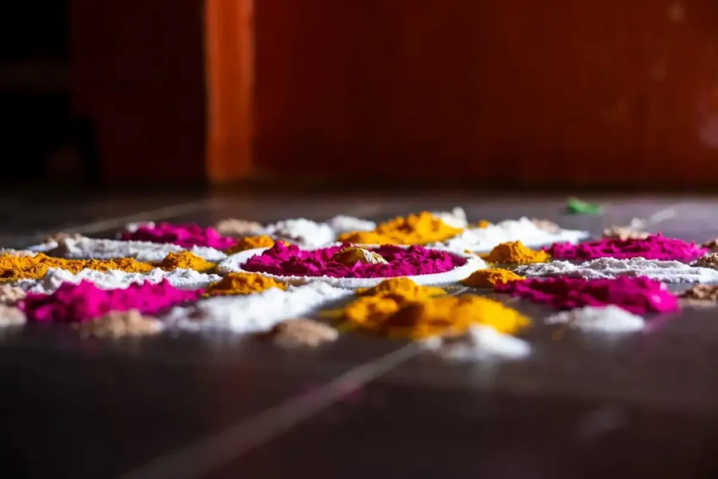 Close-up of a small rangoli with dots filled in pink, yellow, and white natural colors