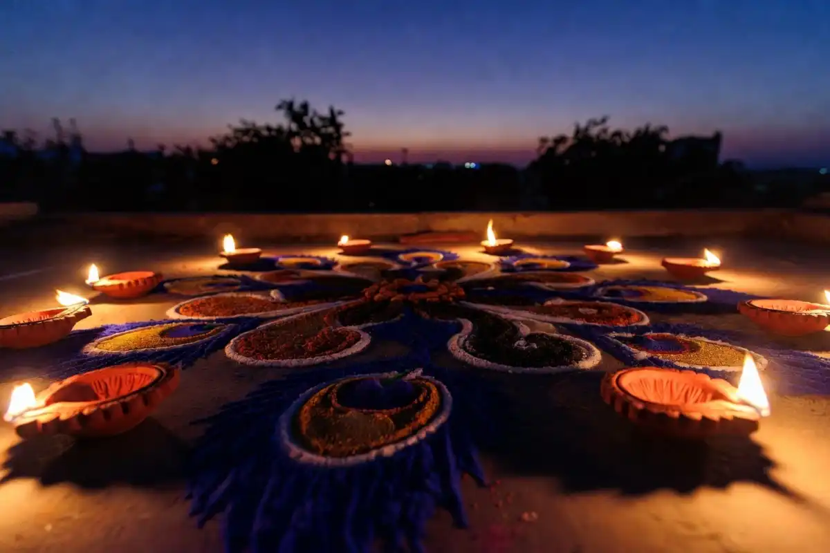 Traditional rangoli design for Diwali 2024 decorated with clay diyas and flower petals
