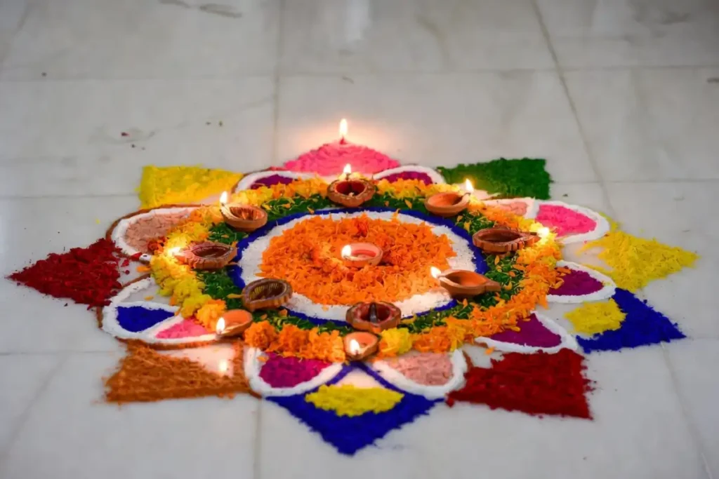A unique rangoli design made with mixed materials including flower petals, diyas, and colored powder on a marble floor