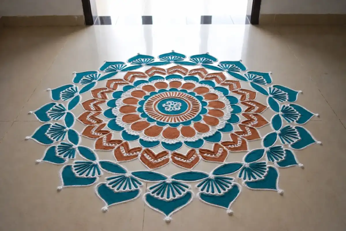 Colorful beginner mandala rangoli with symmetrical circular layers on a doorway floor