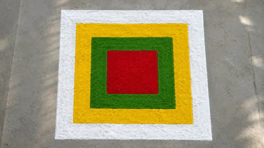 Concentric square rangoli design in white, yellow, green, and red for a beginner-friendly geometric pattern