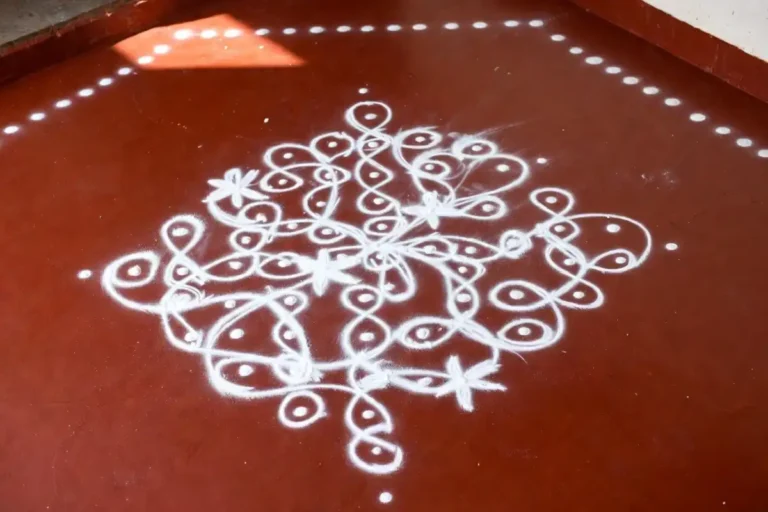 Easy daily kolam design drawn with white rice powder at a home entrance