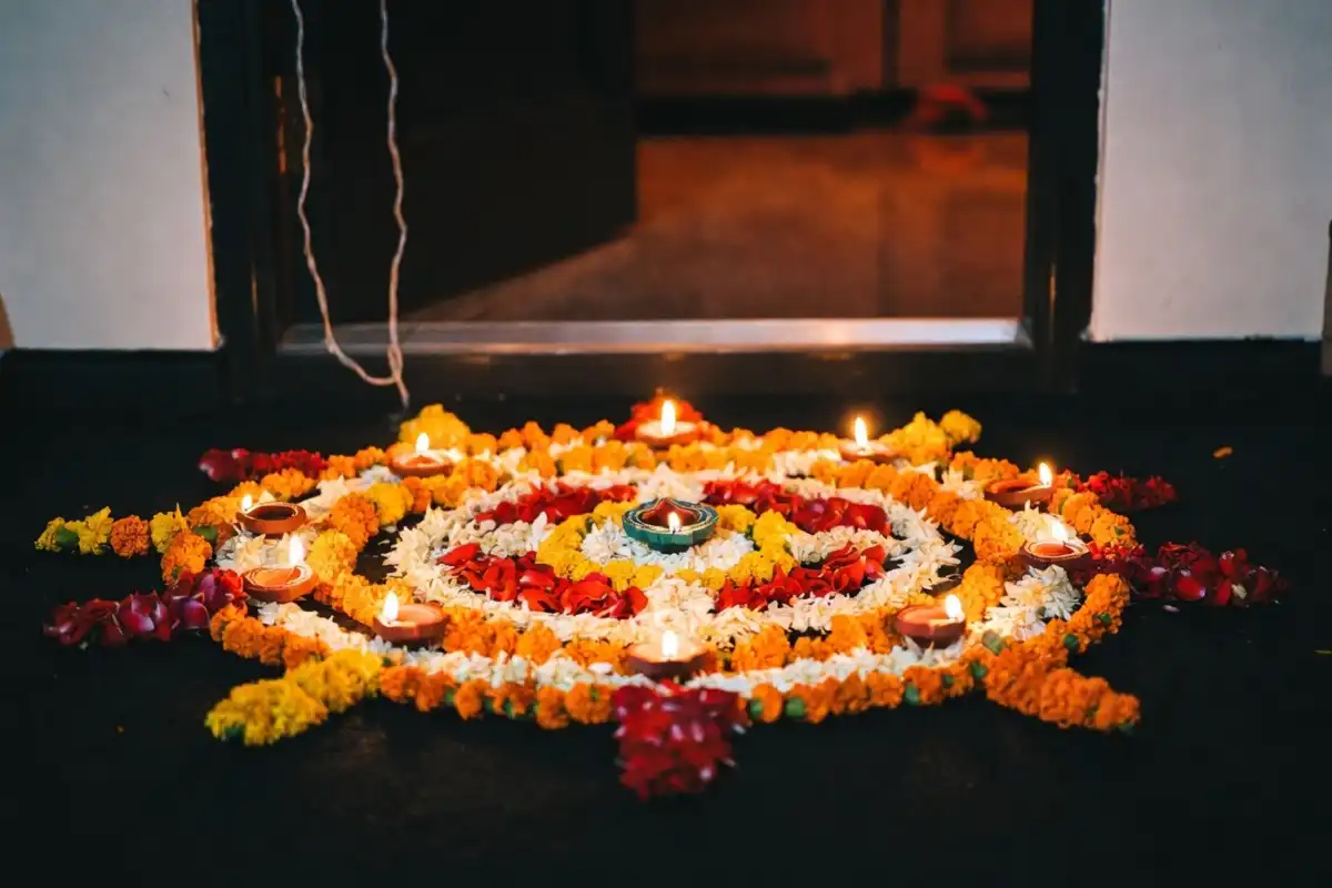 Easy Diwali rangoli at home with flowers and lamps at a doorway