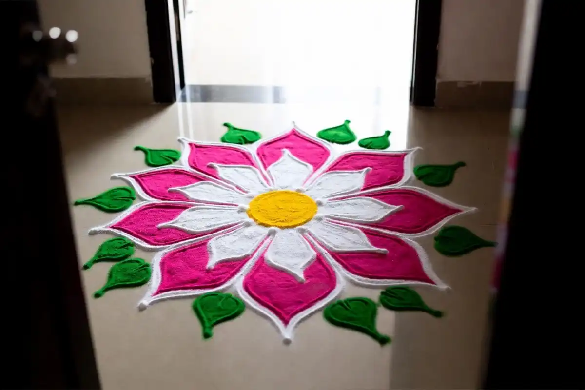 Easy lotus rangoli design in pink and white at a home entrance