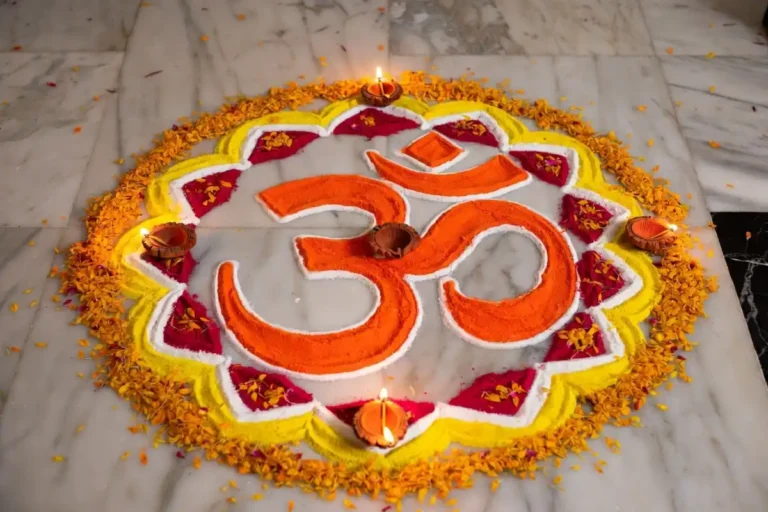 A colorful and symmetrical easy om rangoli design on a marble floor with diyas and flower petals