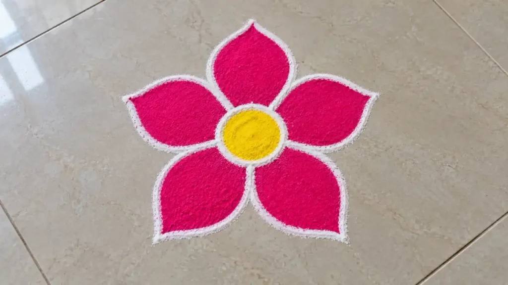 Simple five-petal flower rangoli design in pink and yellow, ideal for first-time rangoli makers