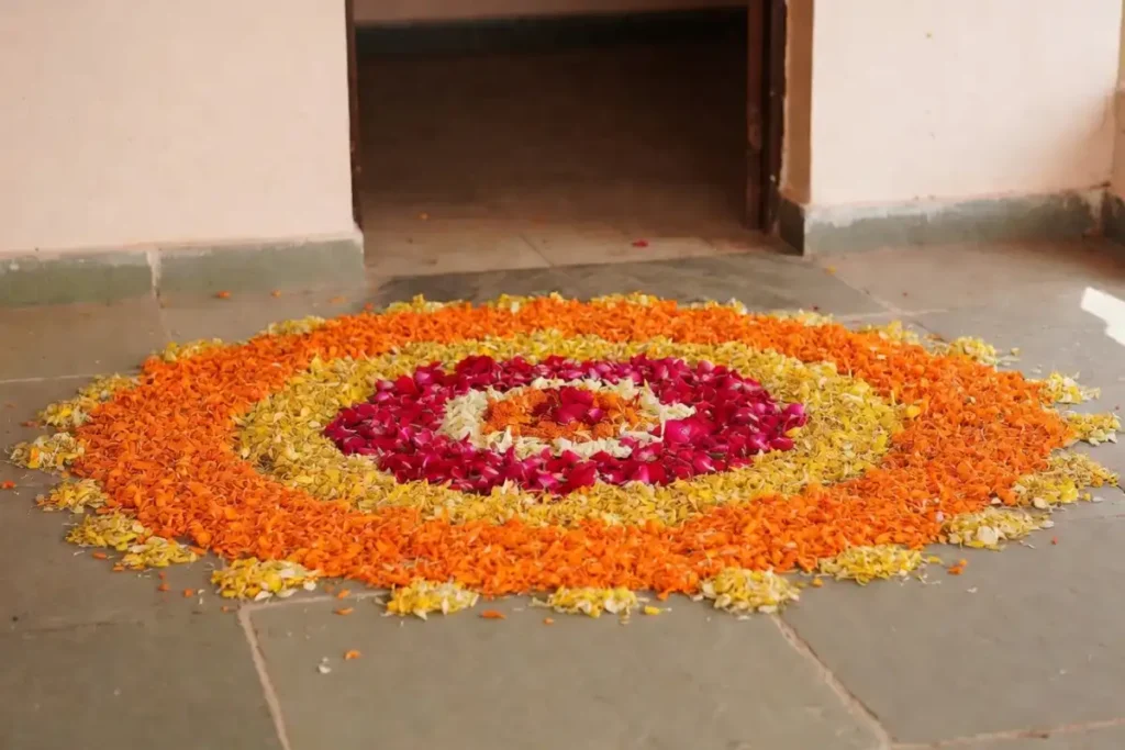 Colorful flower petal rangoli made with natural marigold and rose petals on a stone floor