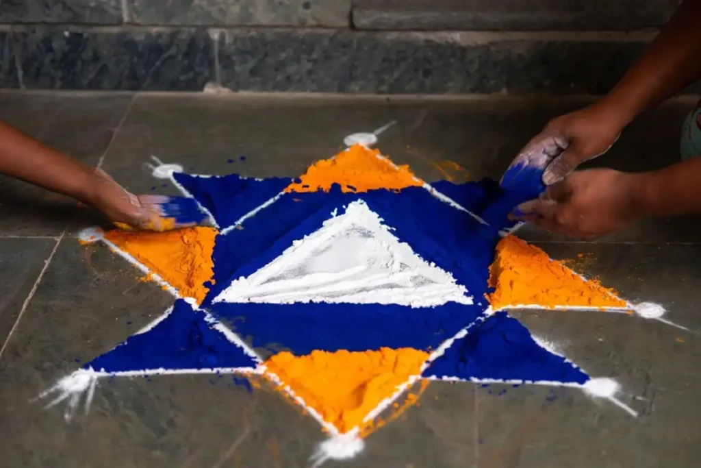 Step-by-step geometric rangoli being drawn with chalk dot guides and colorful powder