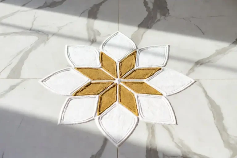 A beautiful minimal rangoli design with soft geometric petals on a white marble floor
