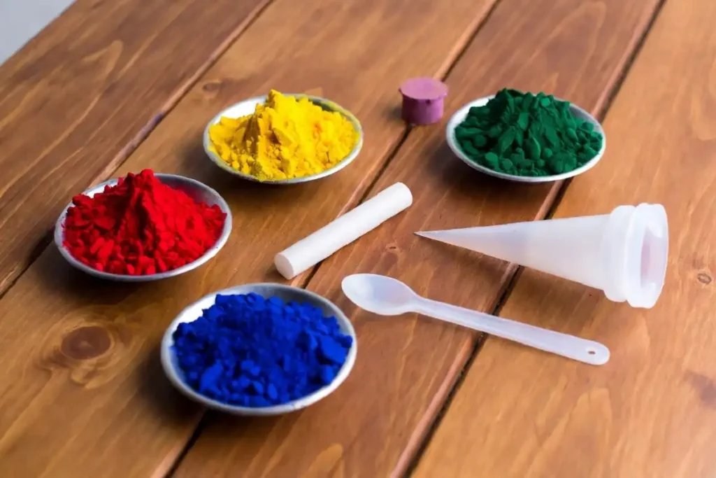 Rangoli tools including powder bowls, chalk, and a cone laid out neatly on a table