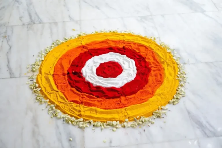 Simple circle rangoli design with concentric colorful rings on white marble floor