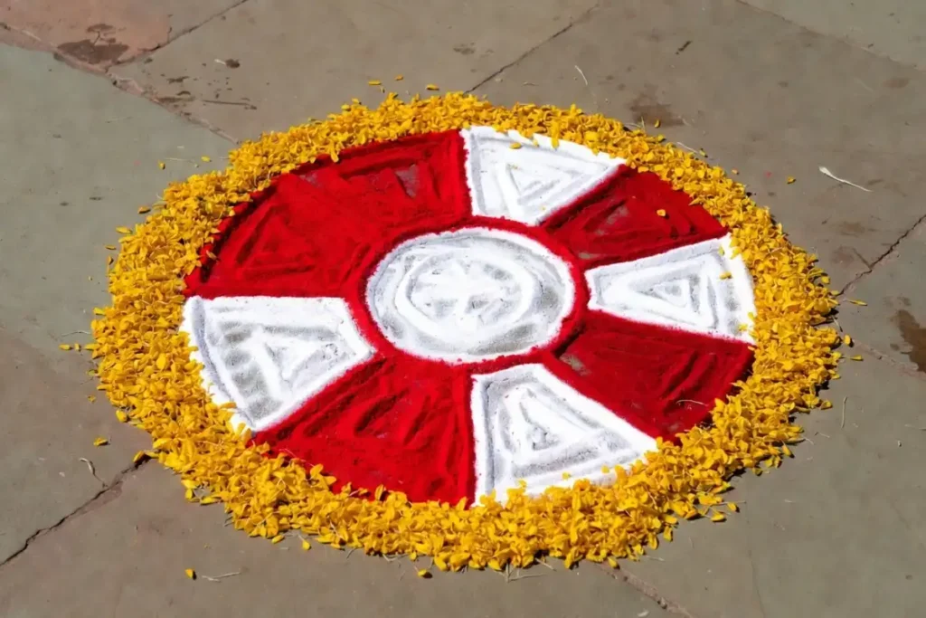Geometric simple circle rangoli with red and white divided ring sections and a marigold petal border