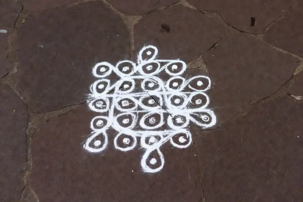 Simple dot-based kolam design for beginners drawn on a stone floor