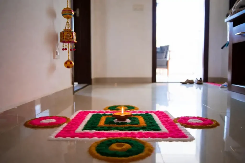 Small geometric rangoli with a lit diya in the center placed at a home entrance during a festival