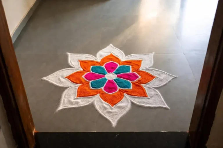 Small symmetry rangoli with balanced flower petals at a home doorway