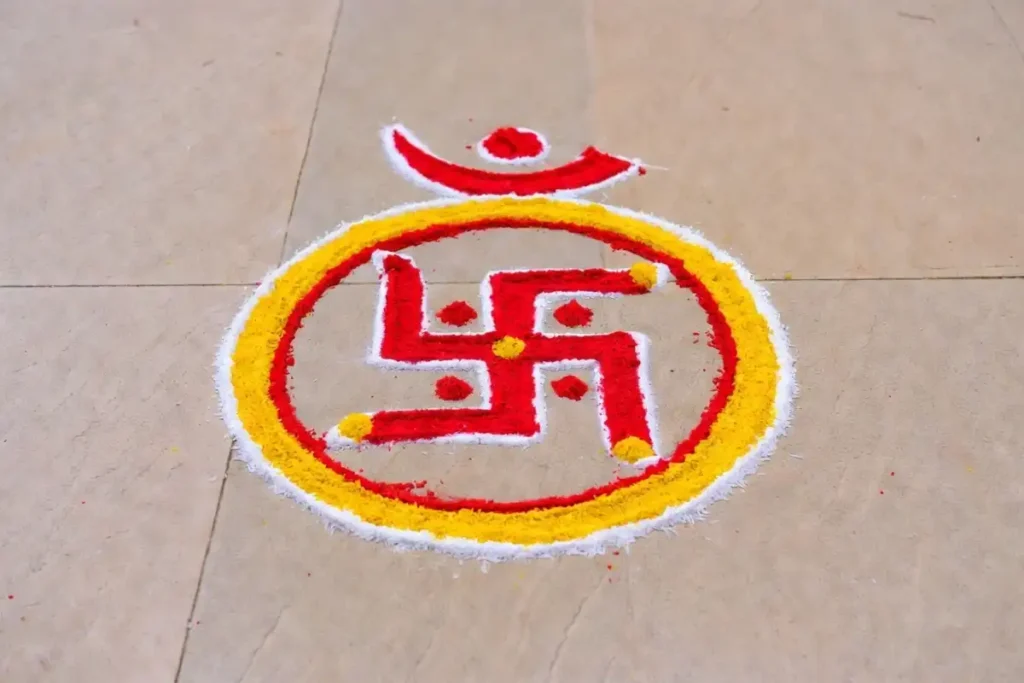 Swastik and Om symbol rangoli design drawn with colored powder