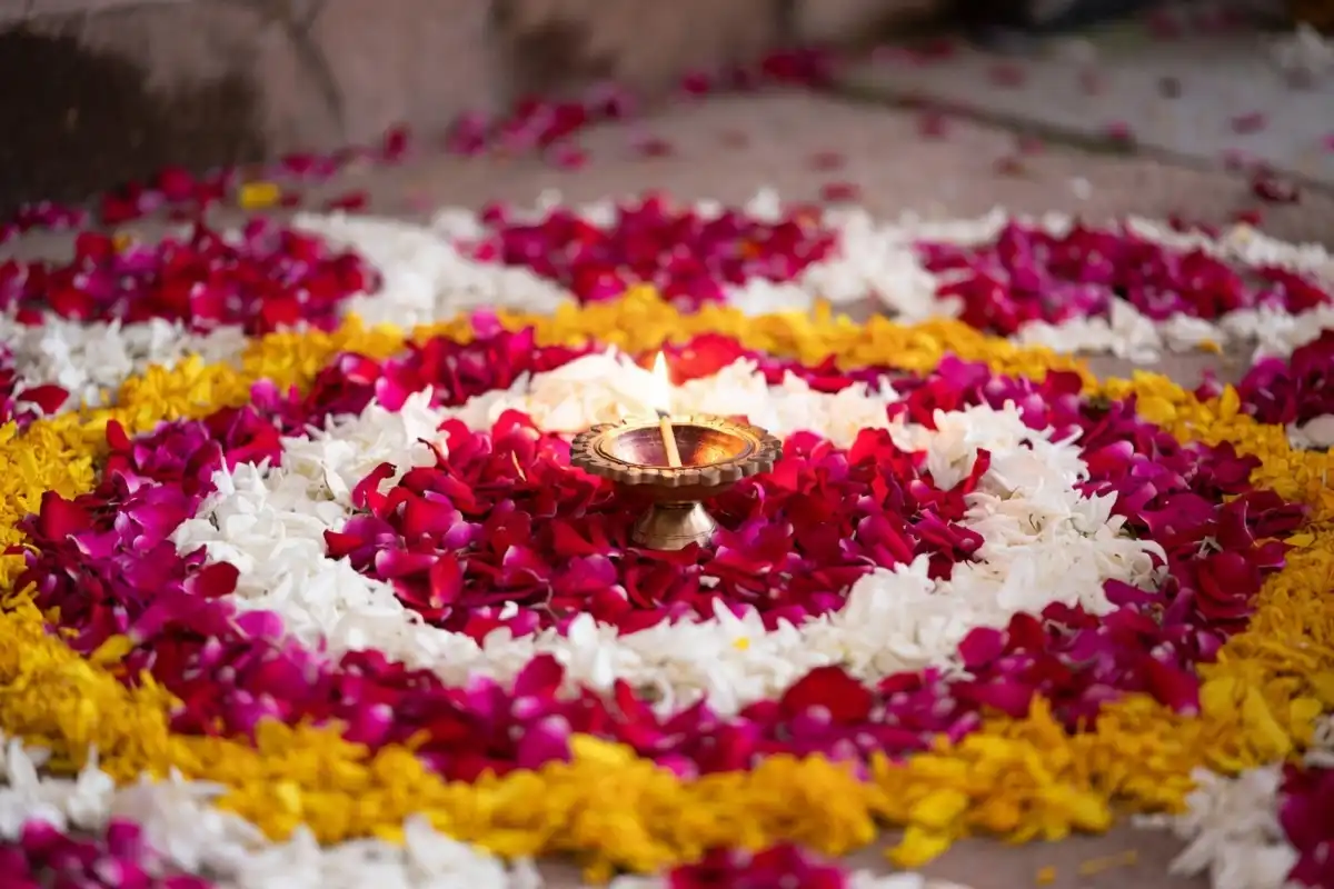 Fresh rose petal rangoli ideas arranged in a circular color-ring design with a center diya