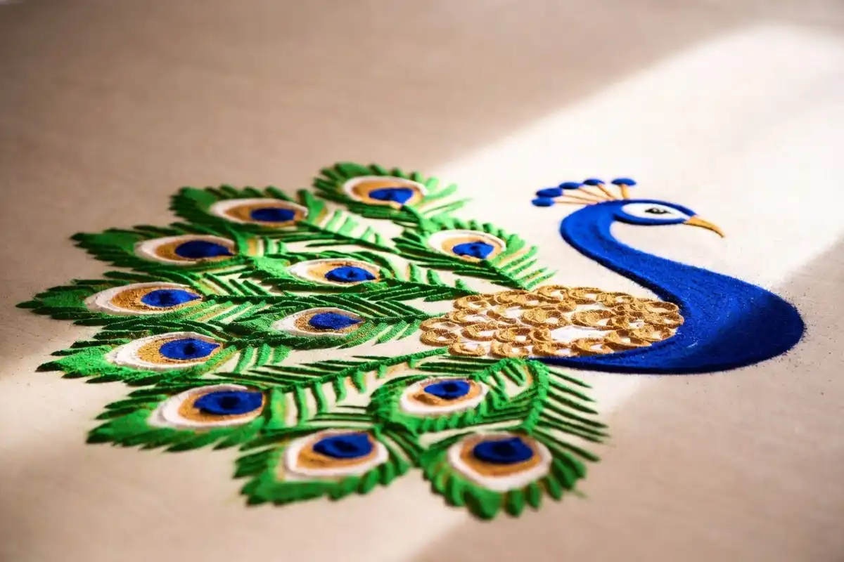 Peacock rangoli in blue, green, and gold, a traditional Indian symbol of beauty and grace