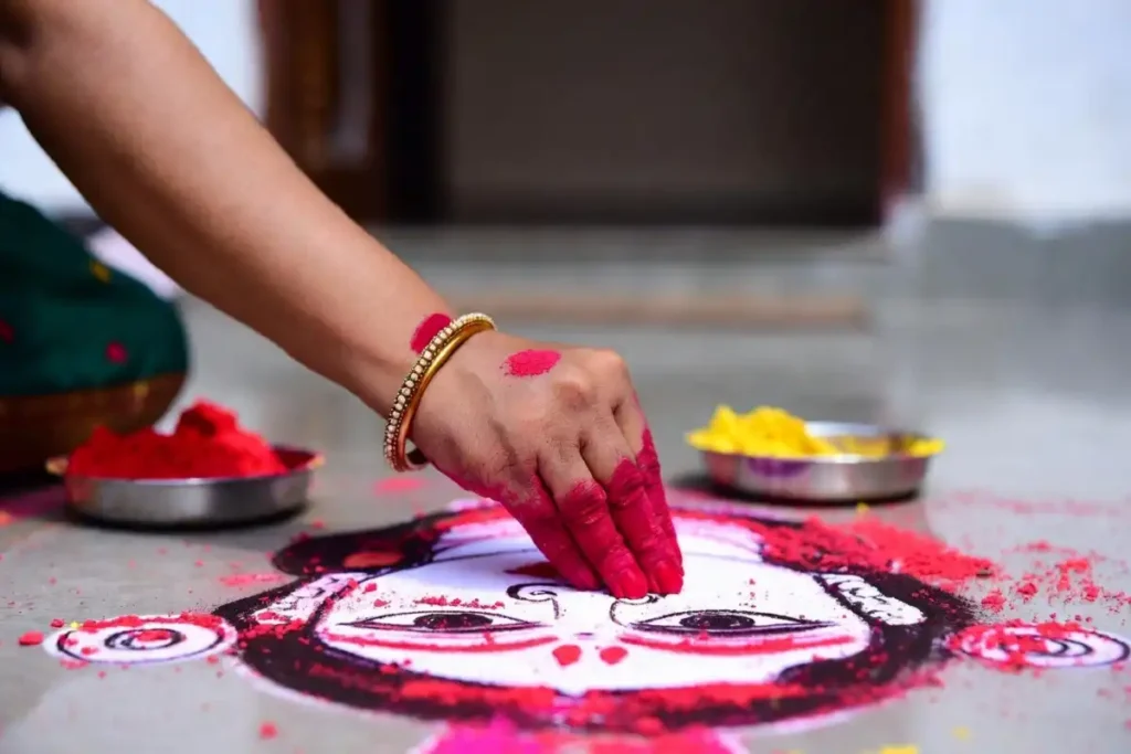 Coloring rangoli designs with Hindu deities using kumkum powder