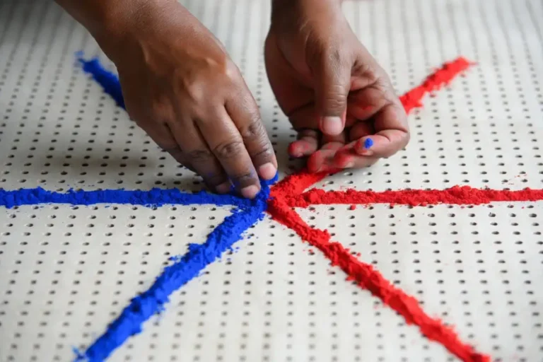 Hands drawing a dot grid for symmetrical rangoli