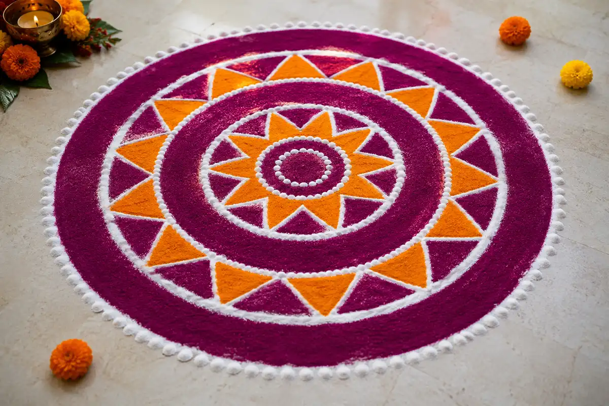 Symmetrical rangoli combining concentric circles and orange triangles in a festive design