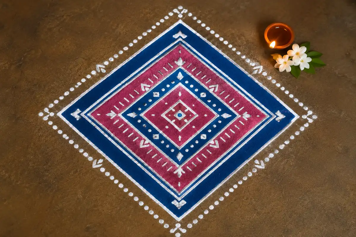 Layered diamond mandala rangoli with pink, blue and white geometric patterns