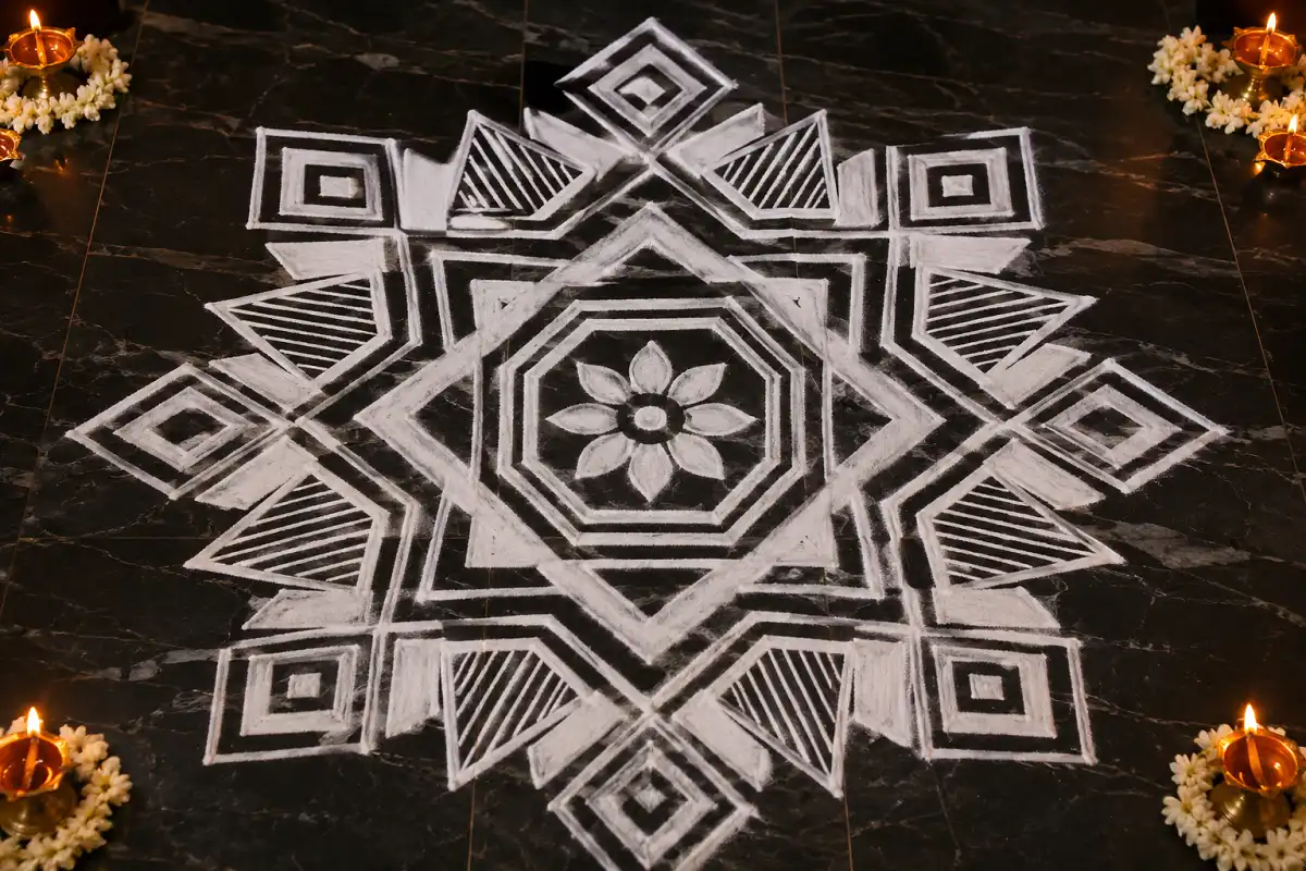 White geometric rangoli with squares, diamonds, triangles and hexagons arranged symmetrically