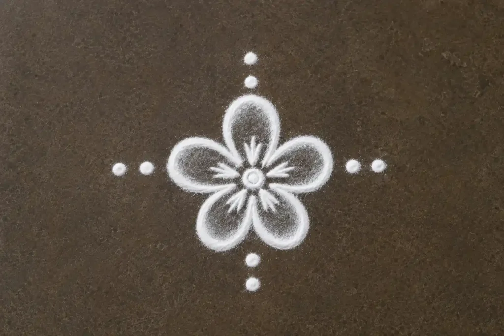 Tiny five-petal flower rangoli design with white powder and decorative dots